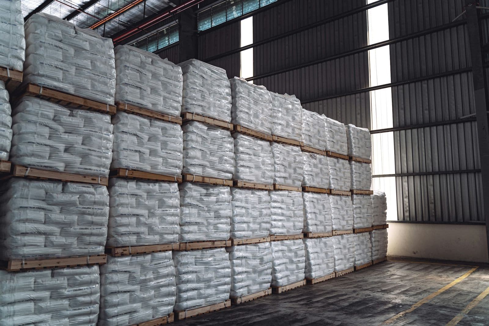 Pallets of shrink-wrapped bulk bags in a warehouse
